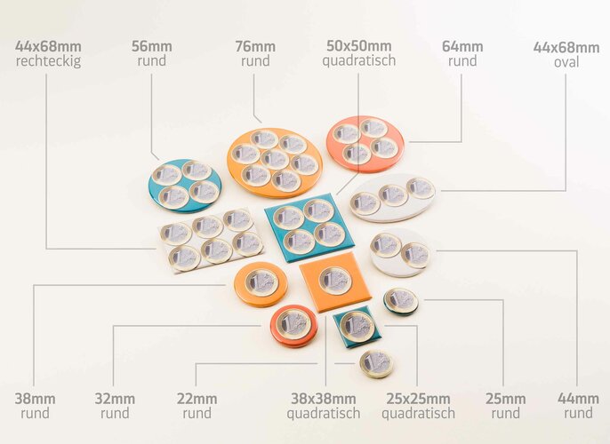 Verschiedene bunte, runde und quadratische Buttons und Anstecker liegen auf einem hellen Hintergrund. Jede Buttongröße wird im Größenverhältnis verglichen mit einer Geldmünze und Buttons sind mit Maßen, wie „76mm rund“ und „50x50mm quadratisch“, beschriftet.